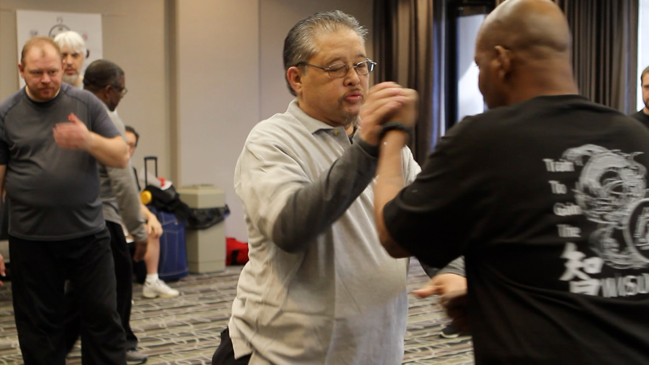 Photo of Sijo Alferos teaching students martial arts moves.
